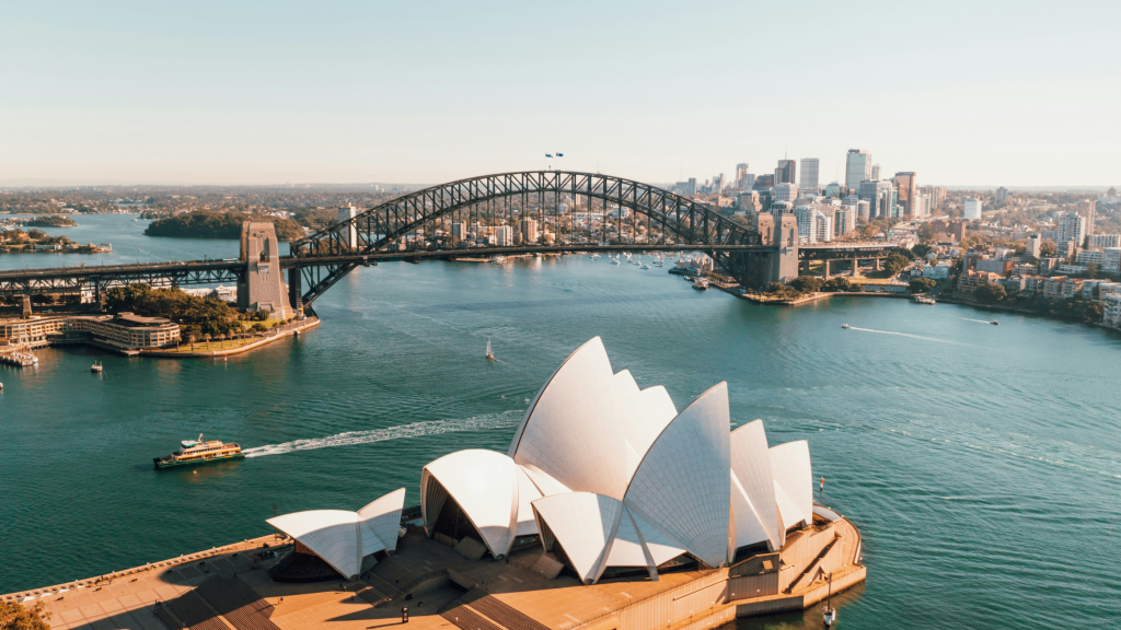Sydney Opera House and Harbour Bridge seen from above on a clear day.