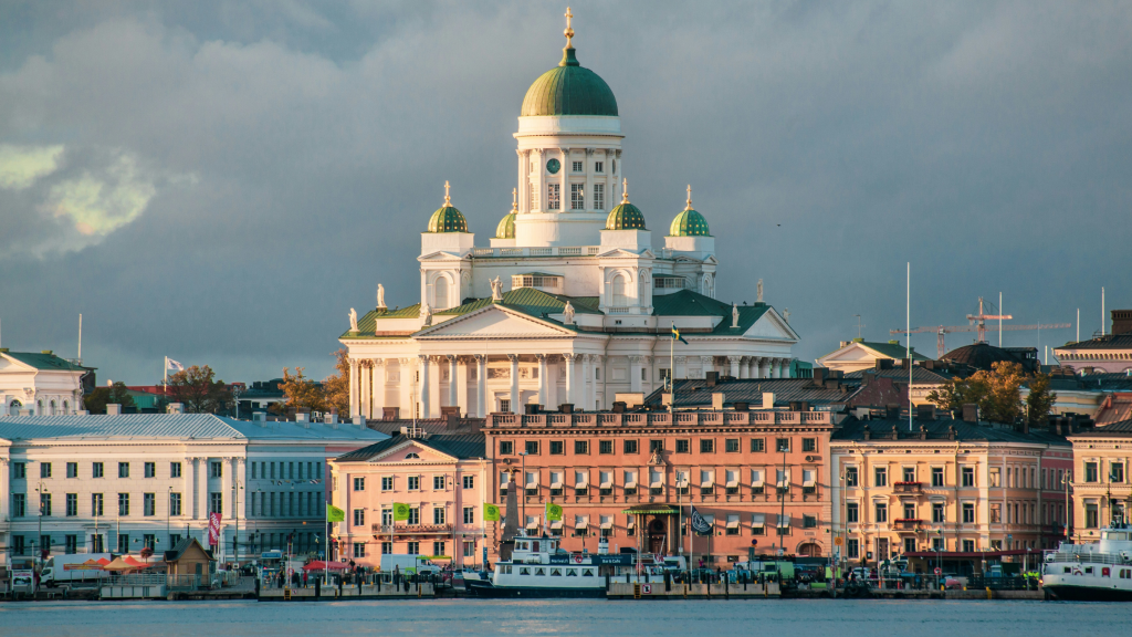 Helsinki Cathedral rising above the waterfront and surrounding buildings under dramatic clouds.