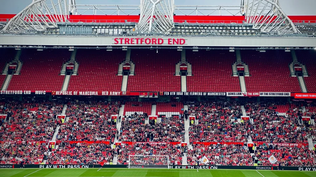 Crowd gathered at the Stretford End inside Old Trafford during a football match.