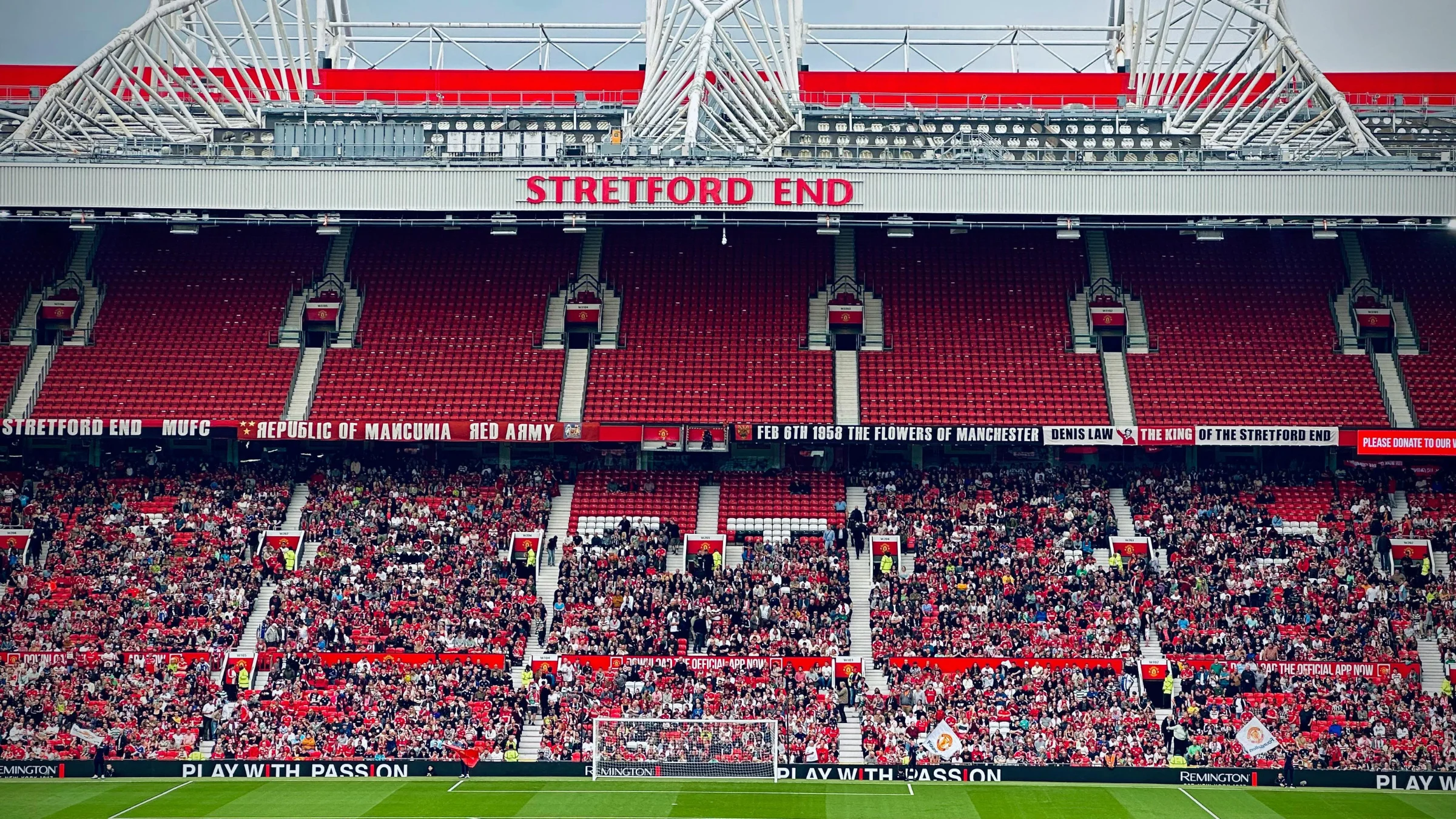 Crowd gathered at the Stretford End inside Old Trafford during a football match.