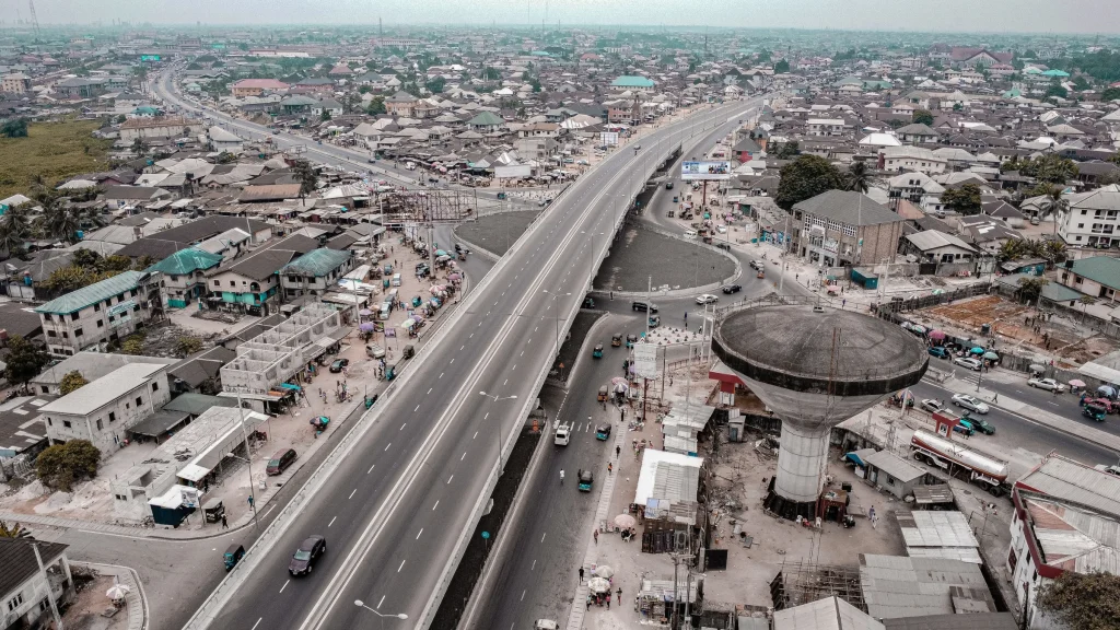Aerial view of a dense urban district with an elevated highway and a large concrete water tower.