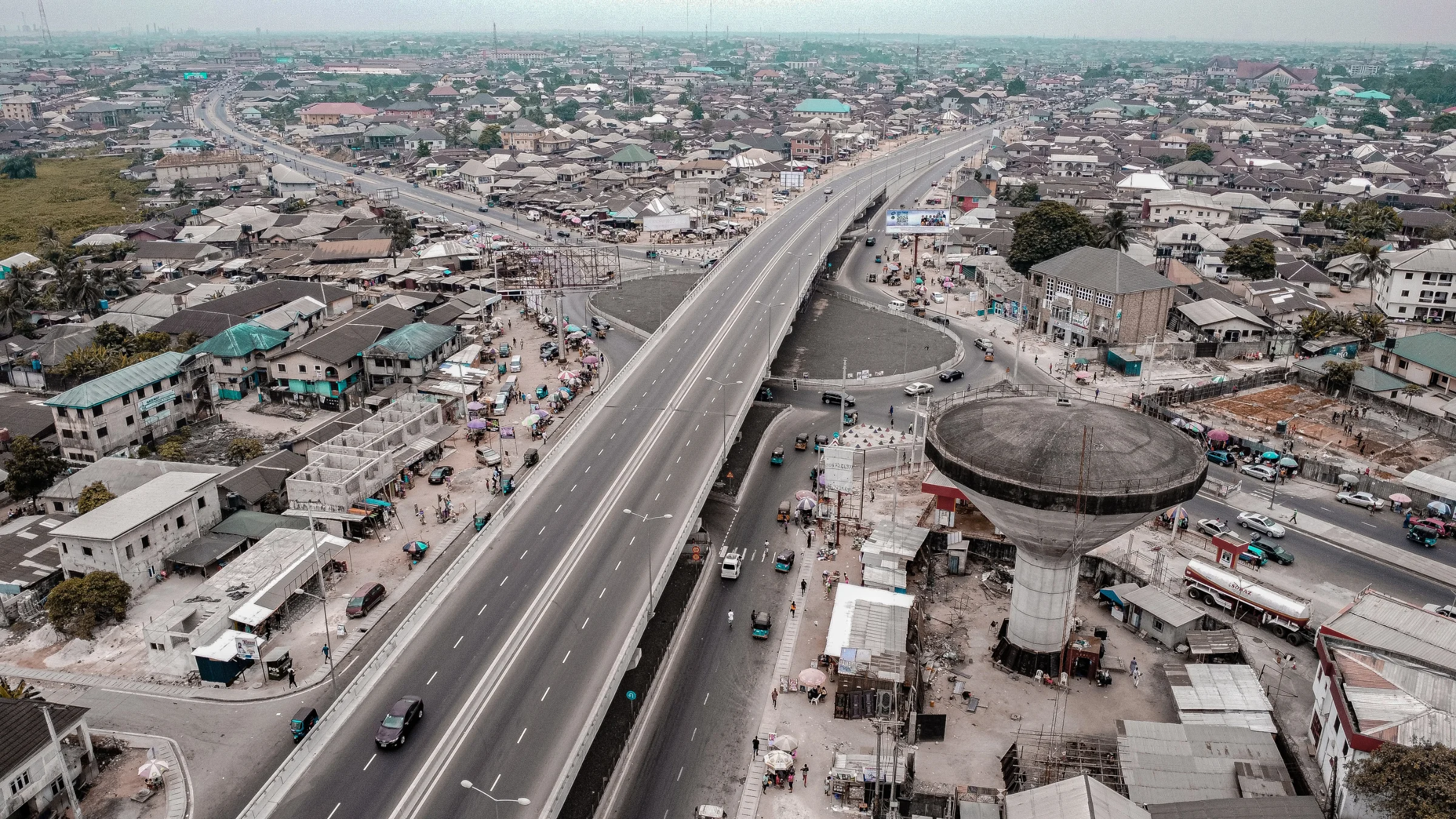 Aerial view of a dense urban district with an elevated highway and a large concrete water tower.