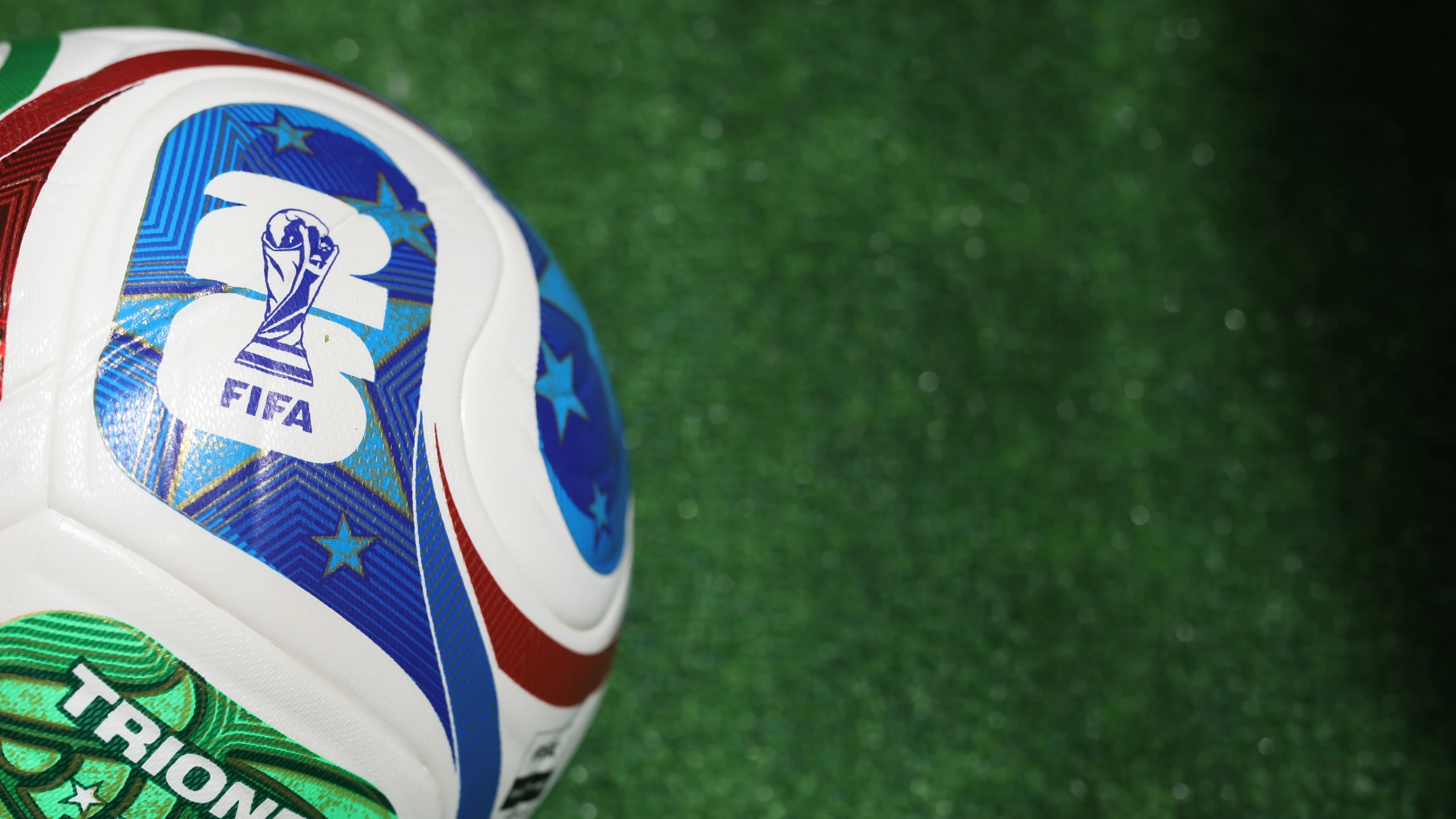 Close-up of FIFA tournament football placed on green artificial turf surface