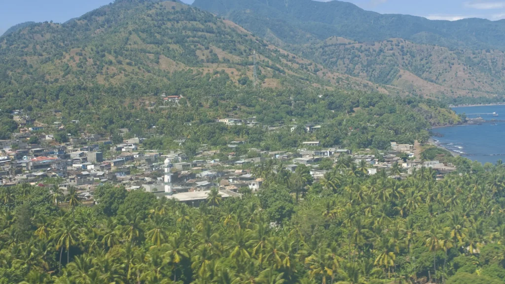 Aerial view of Anjouan island town surrounded by tropical vegetation, coastline and mountainous terrain