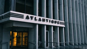 Exterior view of Atlantic City building entrance with “ATLANTIQUE” signage and glass doors at street level.