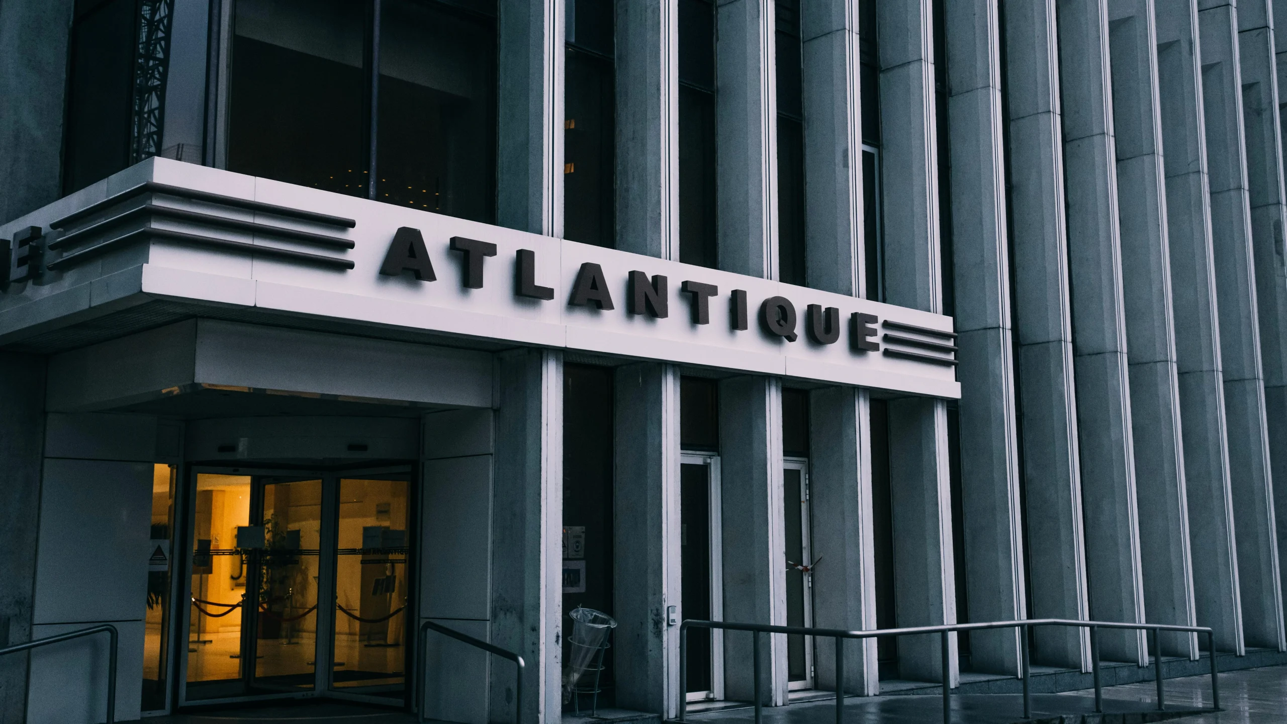 Exterior view of Atlantic City building entrance with “ATLANTIQUE” signage and glass doors at street level.