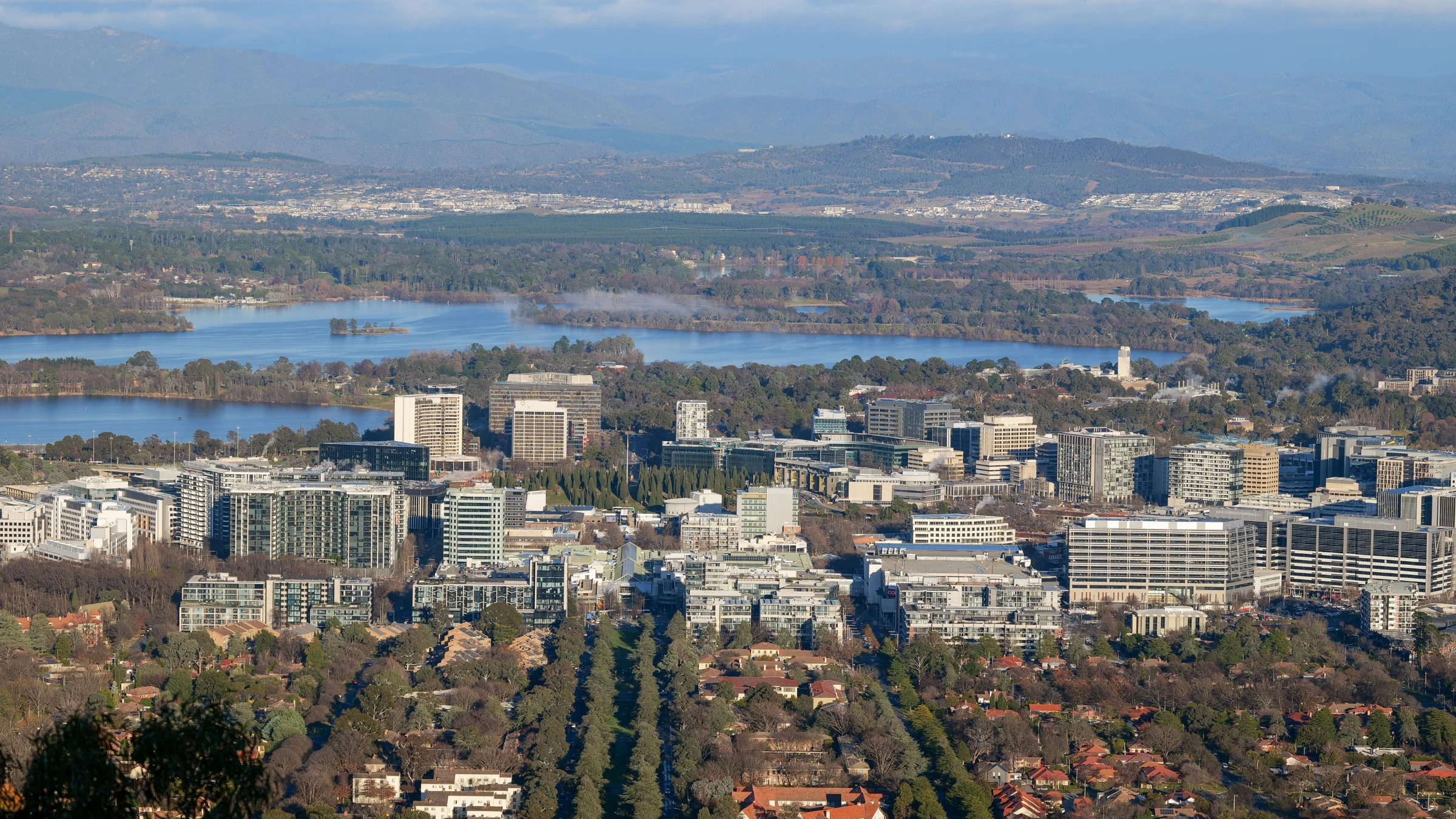 Aerial view of Canberra city centre with Lake Burley Griffin and surrounding hills in the background