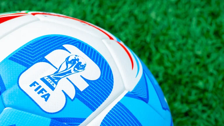 Close-up of FIFA Club World Cup branded football resting on green grass pitch