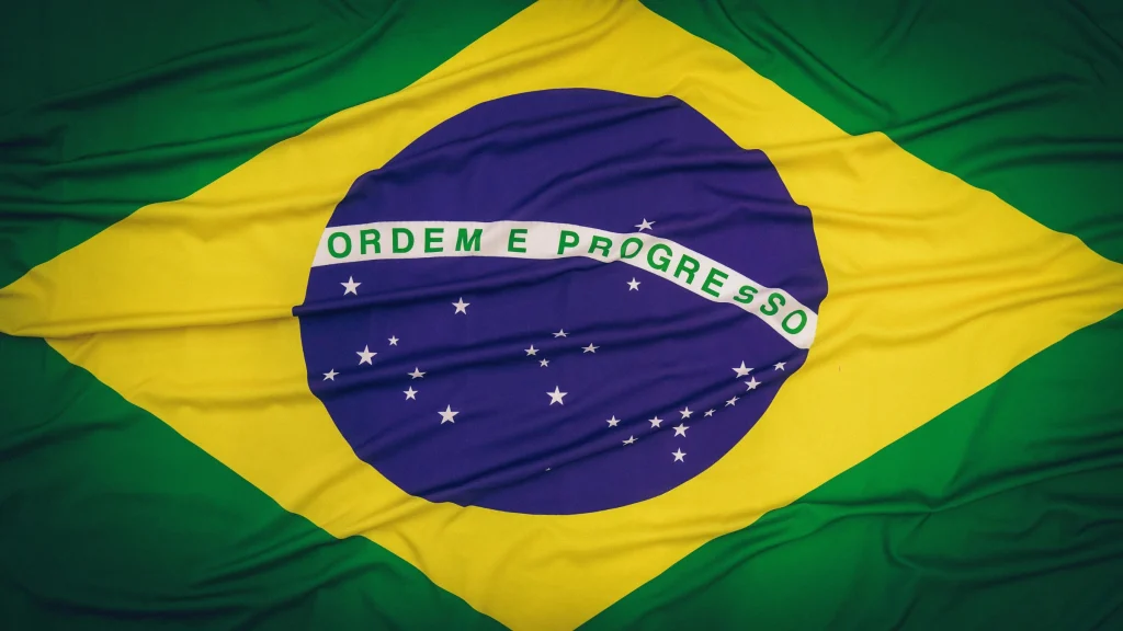 Brazil national flag waving with green, yellow, and blue colors and “Ordem e Progresso” motto.