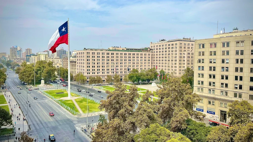 Large Chilean national flag displayed above central Santiago city streets and government buildings