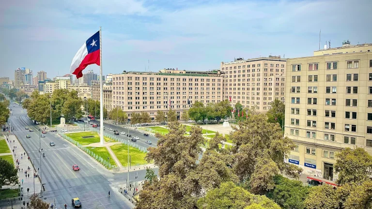 Large Chilean national flag displayed above central Santiago city streets and government buildings