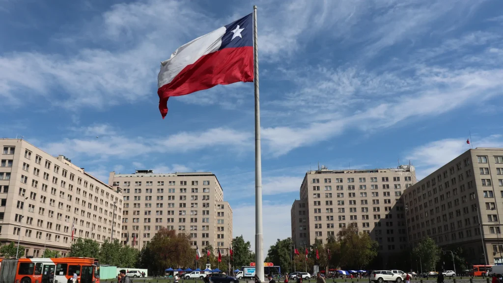 Chilean national flag flying in central city square surrounded by government buildings