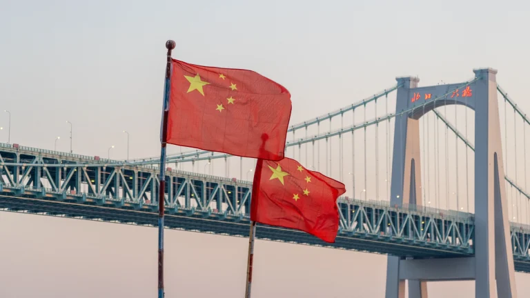 Chinese national flags flying near bridge amid cross-border enforcement cooperation efforts