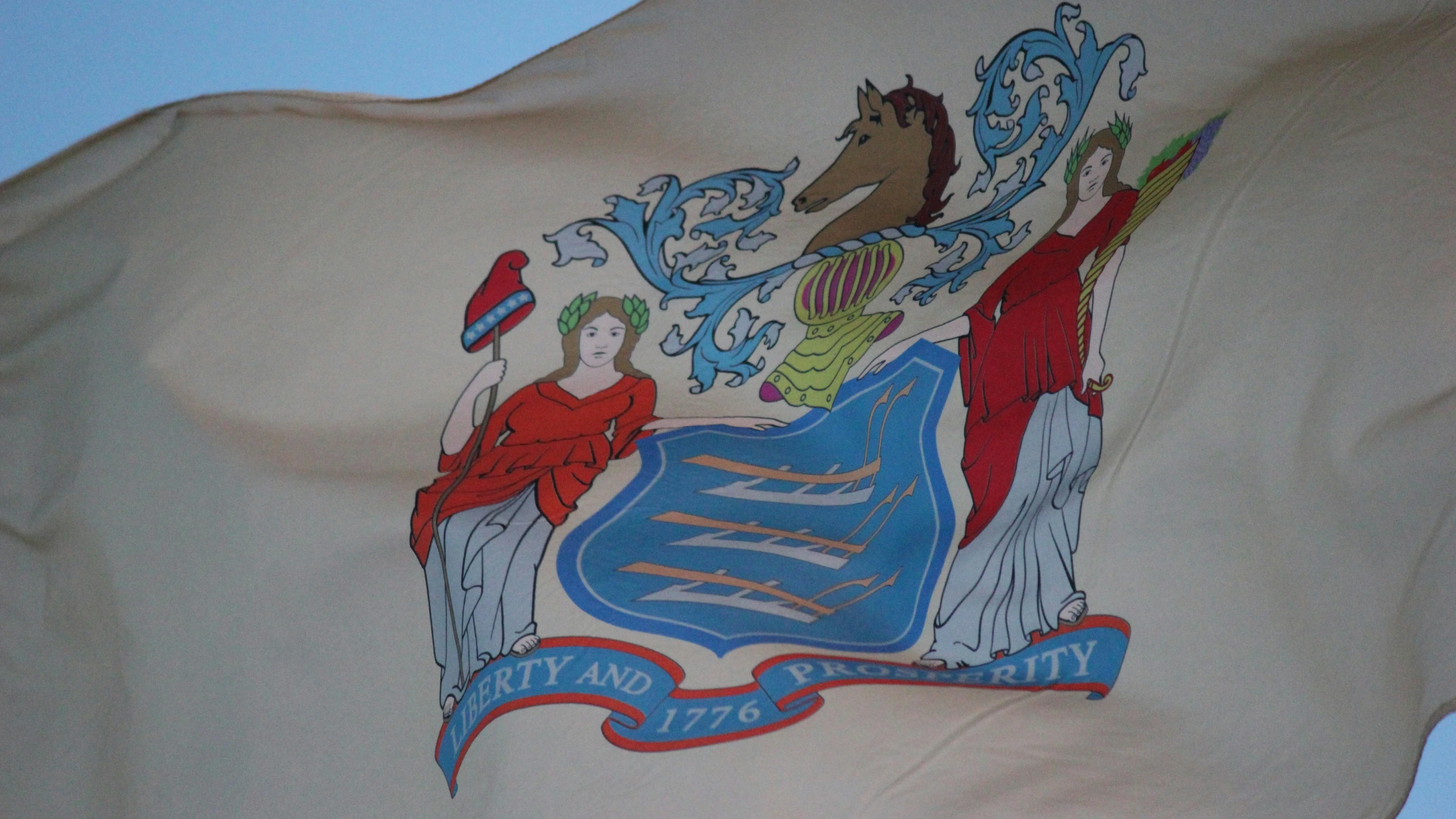 New Jersey state flag waving outdoors featuring official state coat of arms