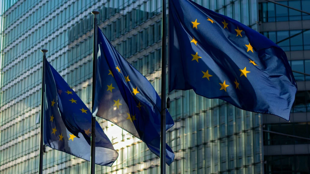 European Union flags displayed outside modern government and office buildings in Europe
