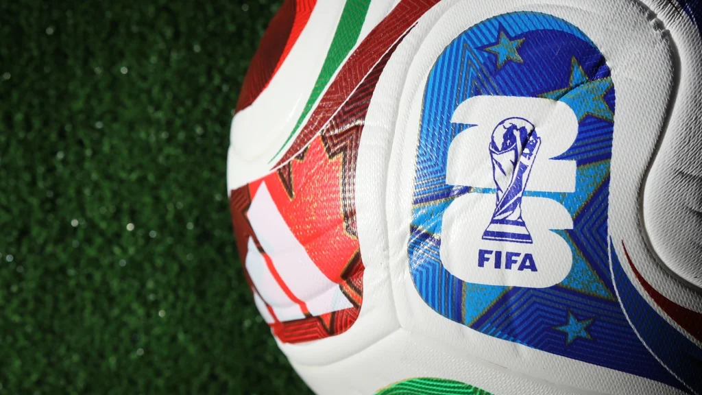 Close-up of FIFA branded football resting on artificial grass surface