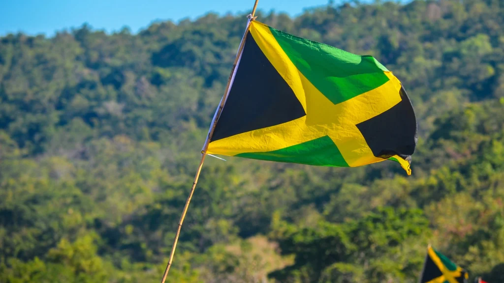 Jamaican flag waving with green hills in the background