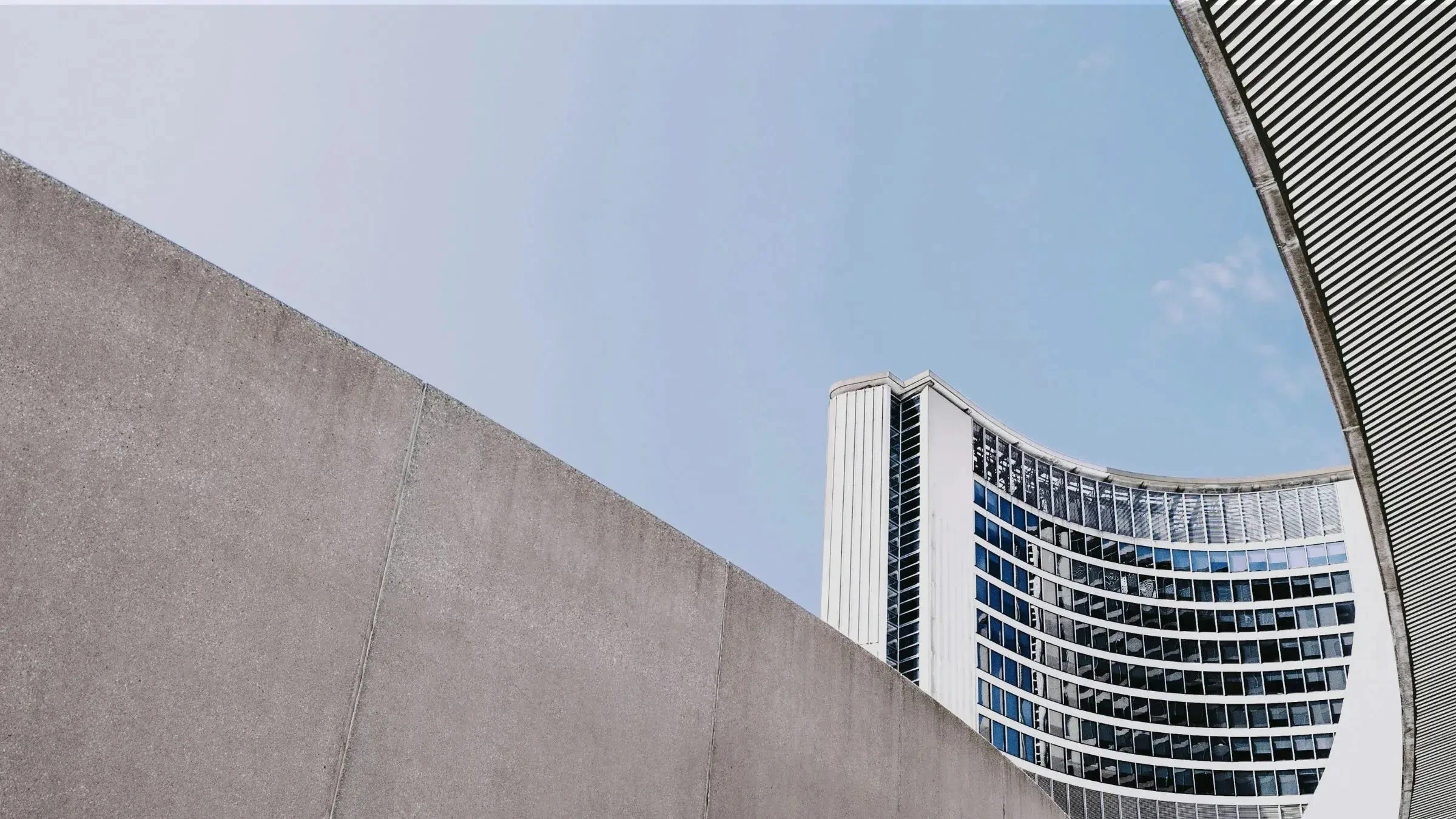 Curved modern government building exterior viewed against clear blue sky in urban area