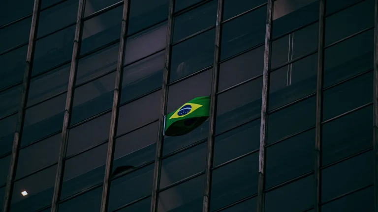 Brazilian flag visible through windows of modern office building facade