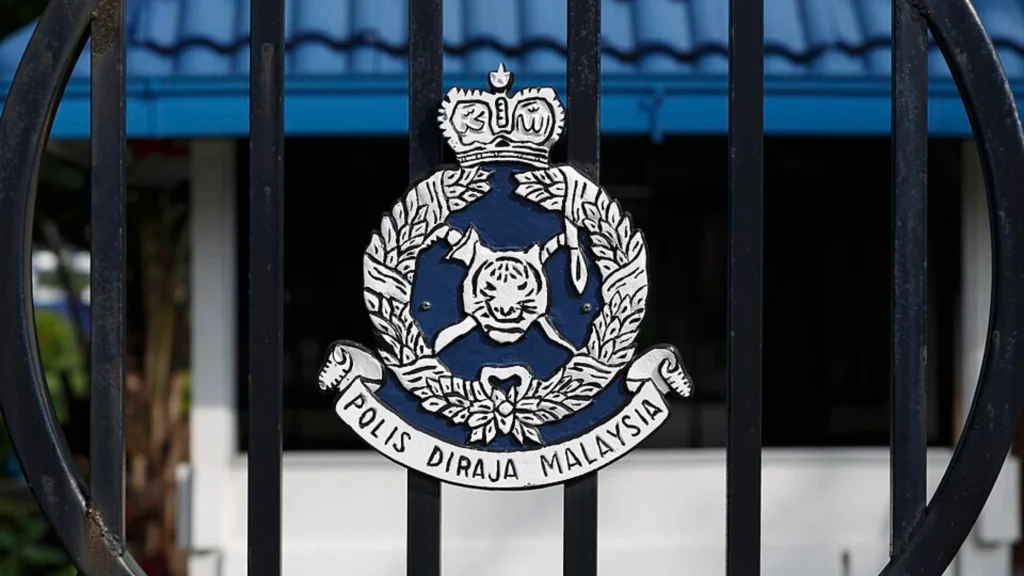Royal Malaysia Police emblem displayed on security gate outside facility
