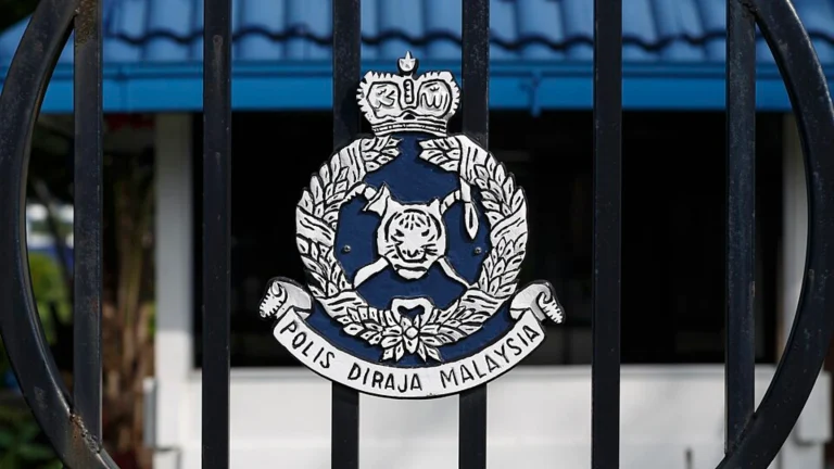 Royal Malaysia Police emblem displayed on security gate outside facility