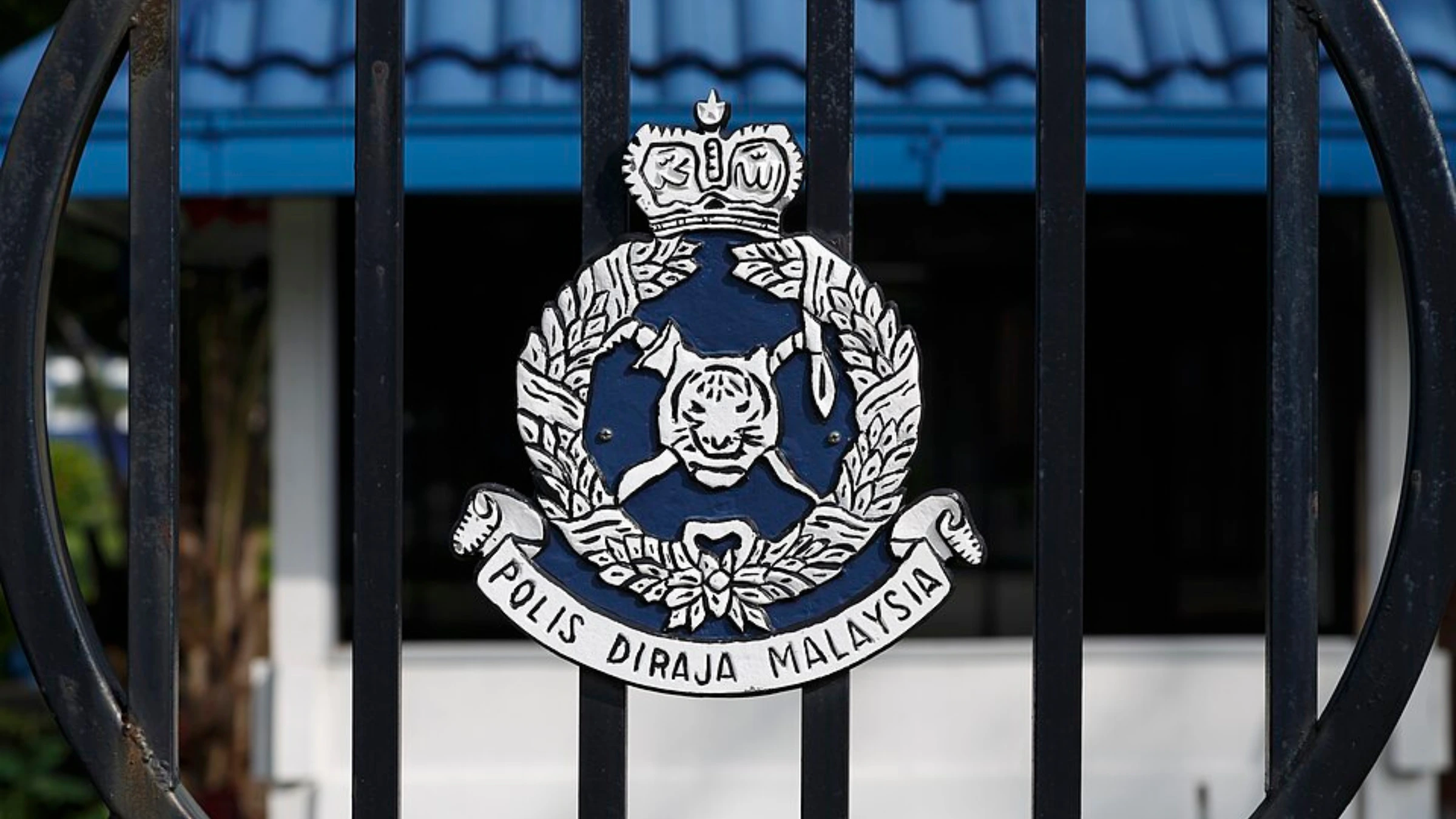 Royal Malaysia Police emblem displayed on security gate outside facility