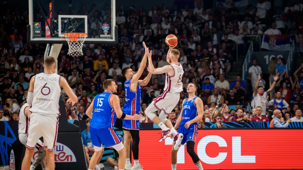Professional basketball game in progress with players contesting a shot near the basket