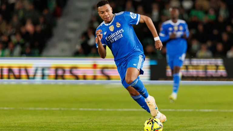Football player Kylian Mbappé dribbling the ball during a competitive club football match