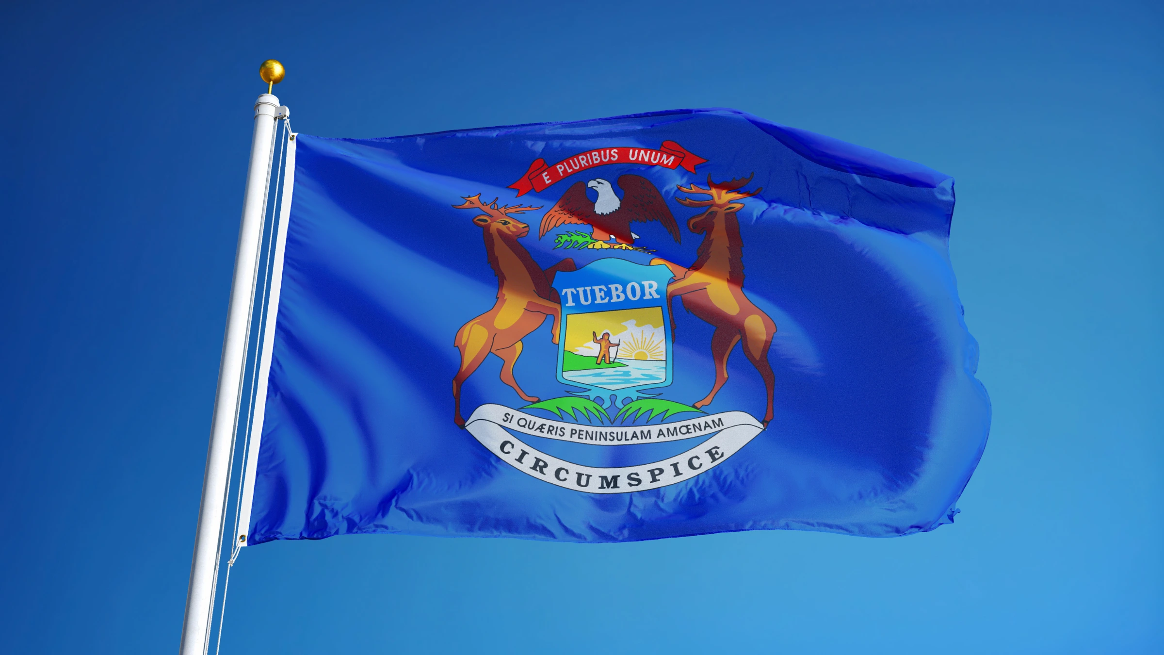 Michigan state flag waving on flagpole against clear blue sky background