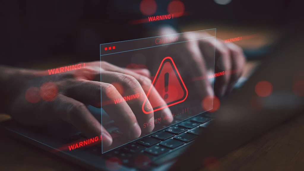 Cybersecurity warning alert shown on computer screen above keyboard activity