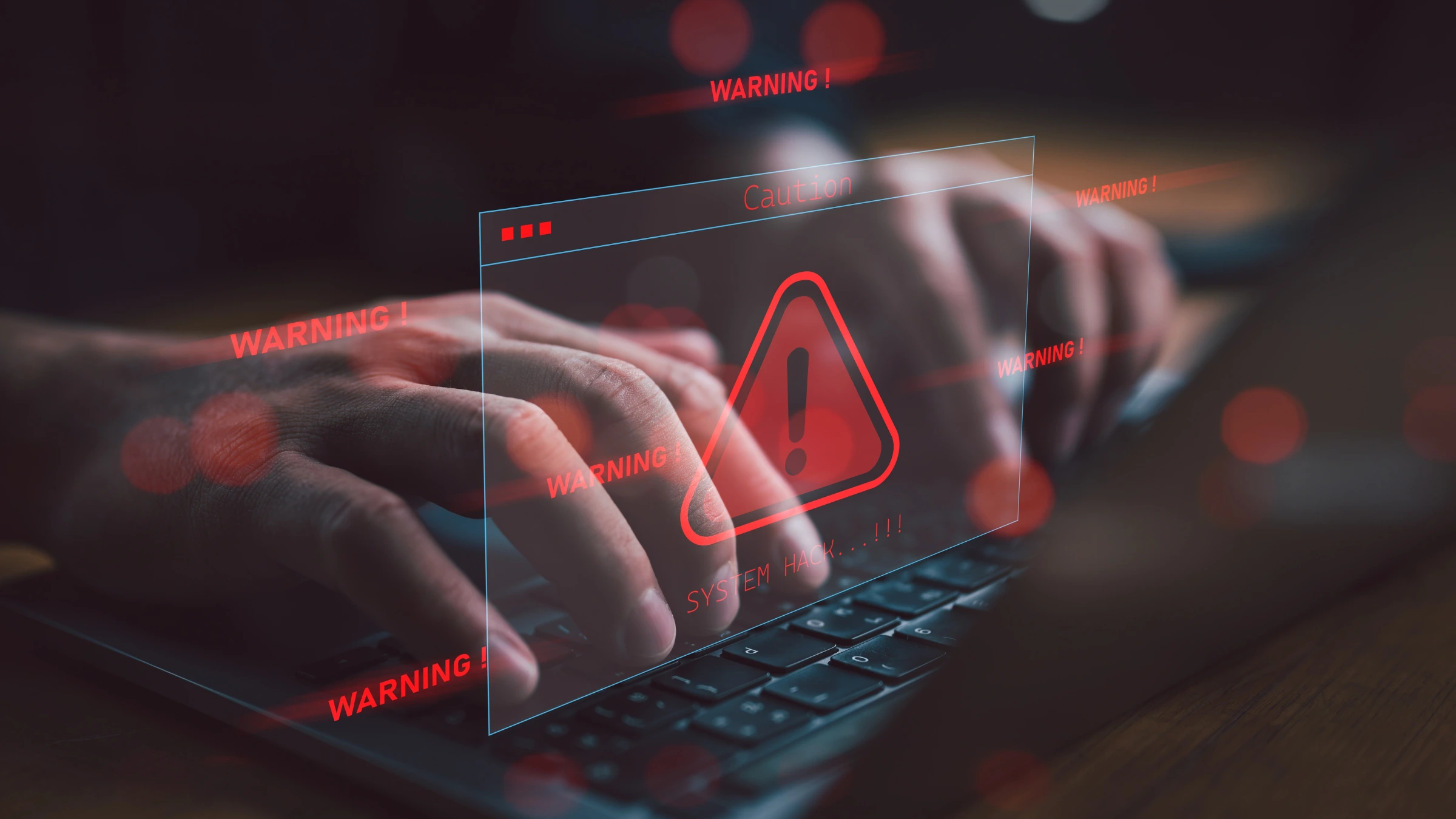 Cybersecurity warning alert shown on computer screen above keyboard activity