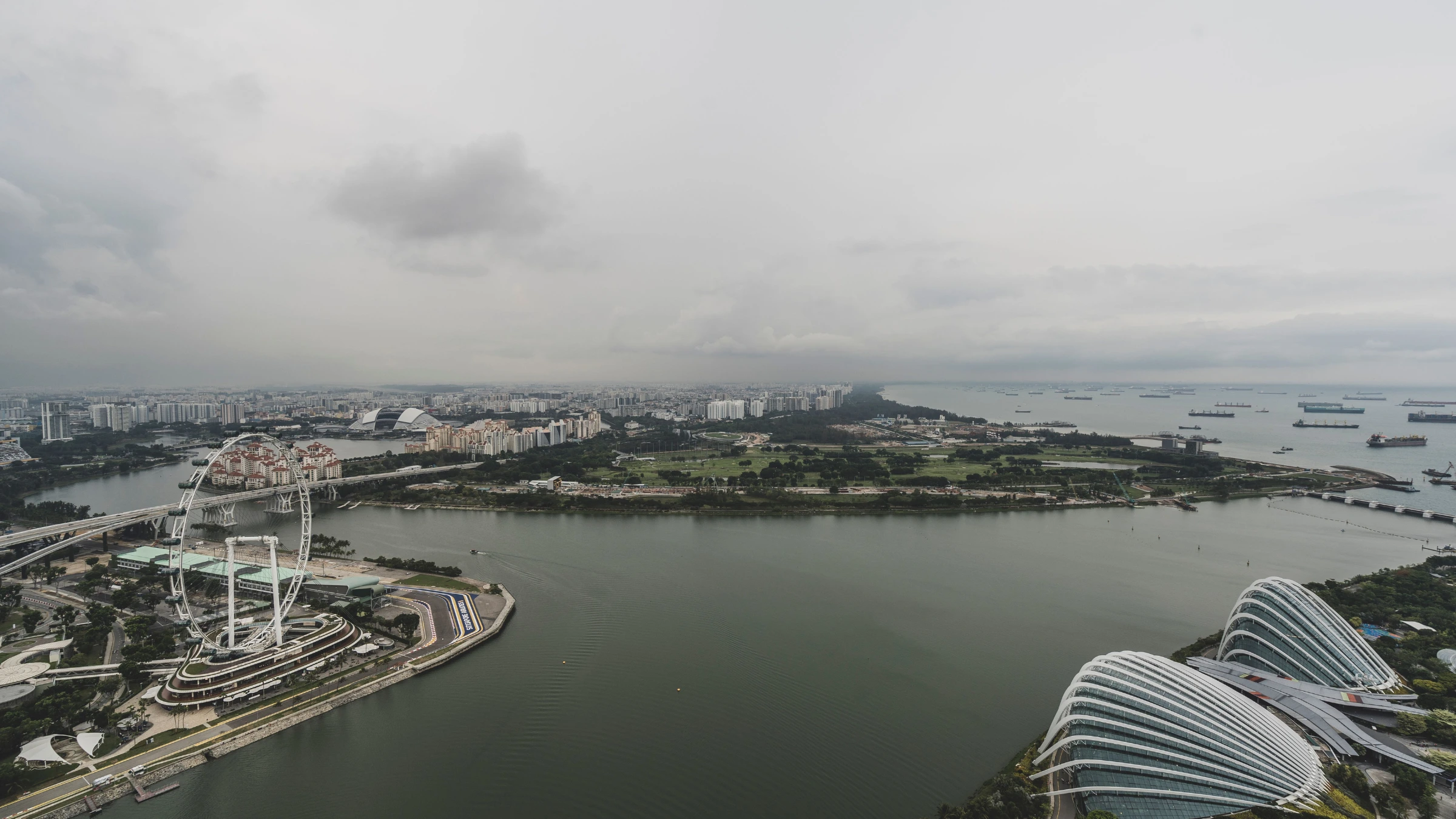 Aerial view of Singapore waterfront with skyline, marina and anchored ships