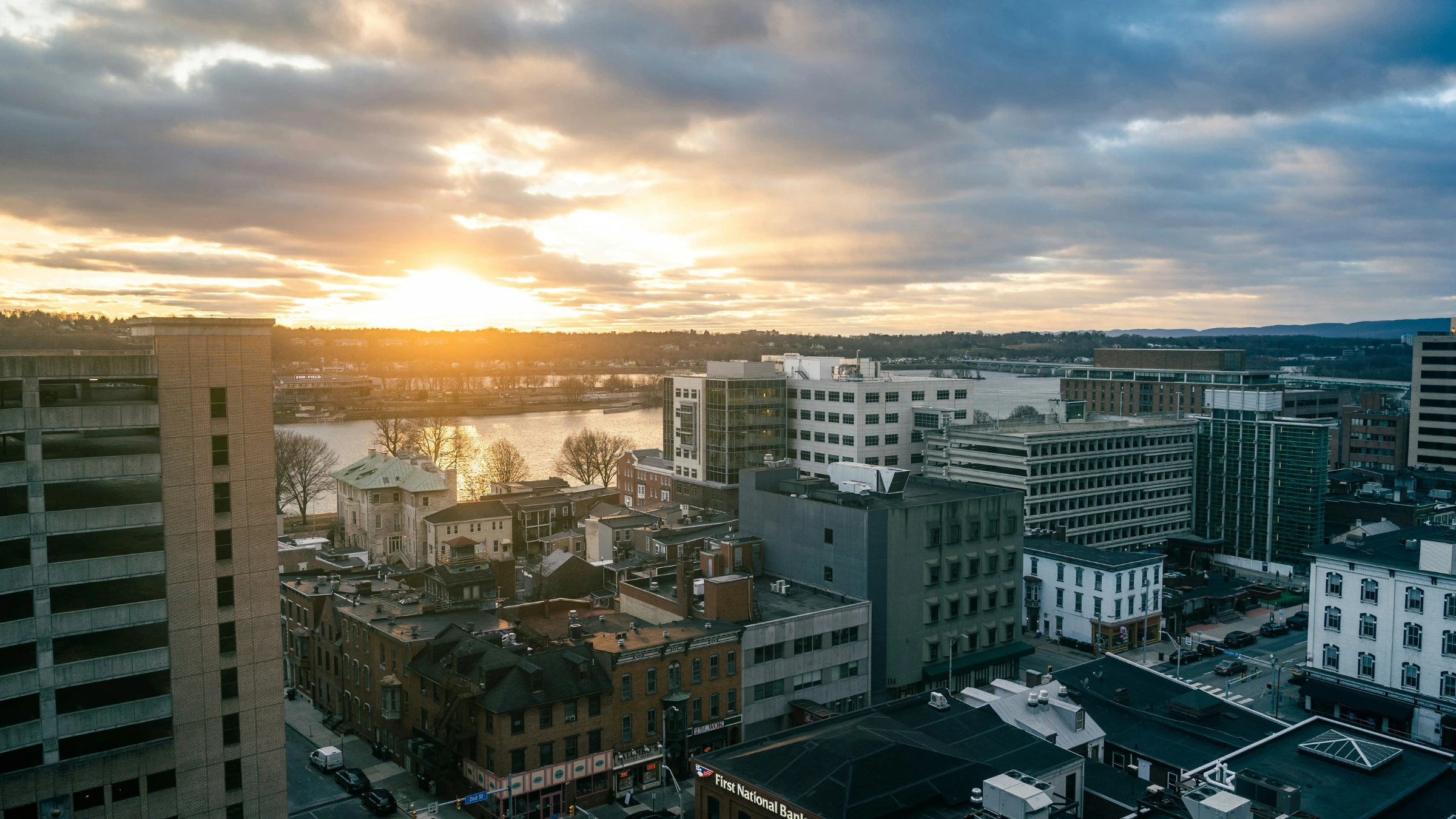 Aerial cityscape at sunset overlooking downtown buildings and riverfront district