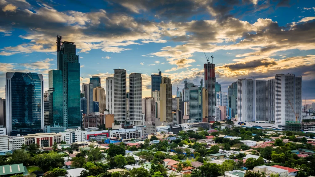 Manila skyline under a dramatic sky, illustrating the Philippines’ tighter enforcement of its POGO ban.