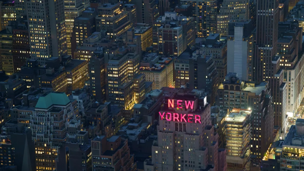 Nighttime aerial view of New York City skyline with illuminated buildings