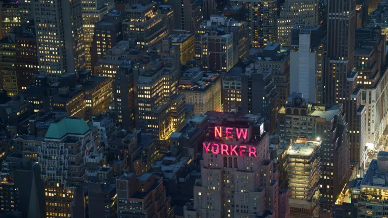 Nighttime aerial view of New York City skyline with illuminated buildings