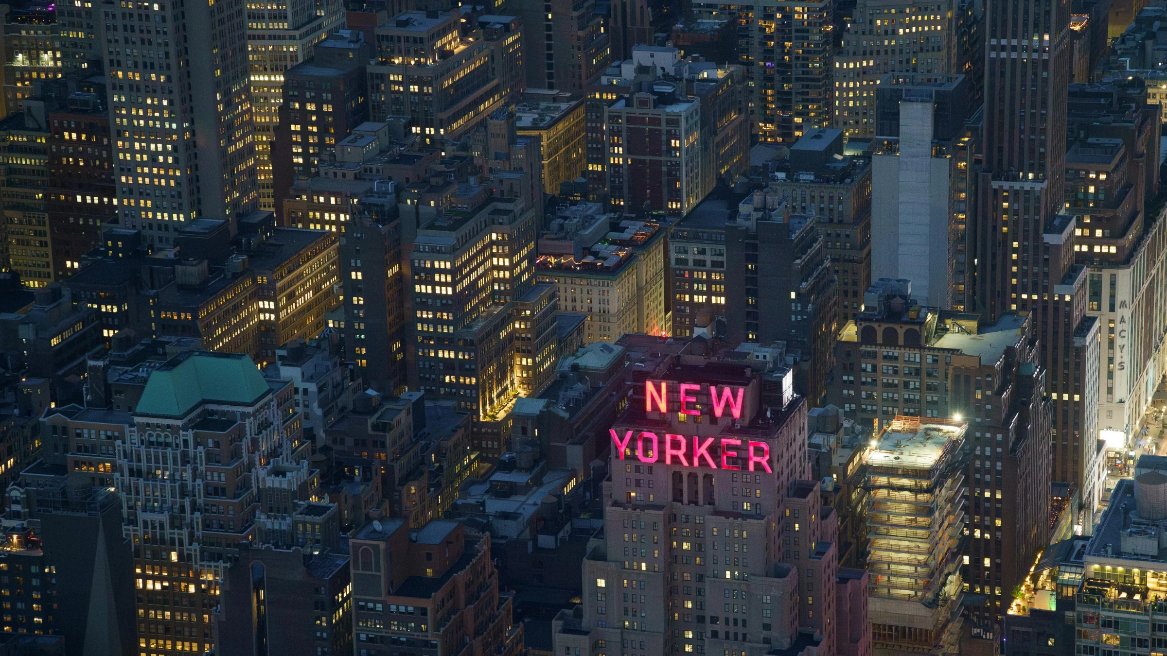 Nighttime aerial view of New York City skyline with illuminated buildings
