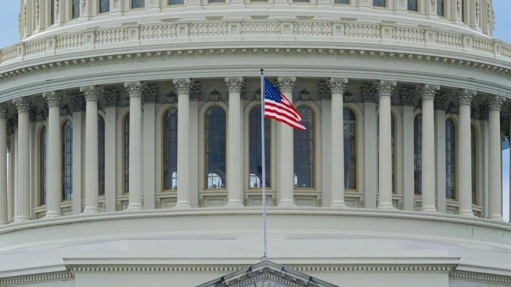 United States Capitol building with American flag waving prominently