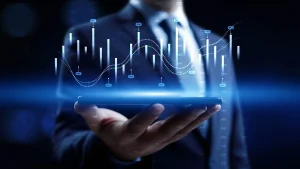 Businessperson holding digital tablet with glowing financial charts and market data graphics displayed