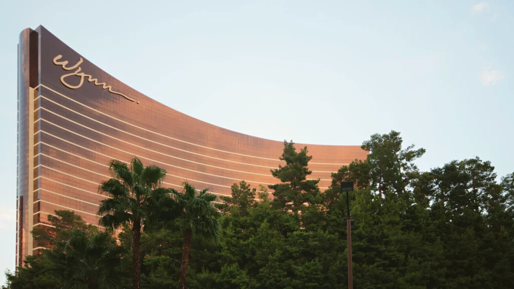 Wynn Las Vegas resort exterior with curved bronze tower and palm trees